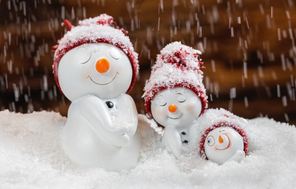 Smiling ornamental snowmen in red hats