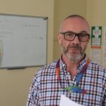 Man stands in front of a whiteboard presenting