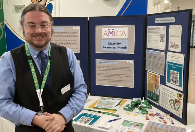 Man standing next to a stall about Disability Awareness Month